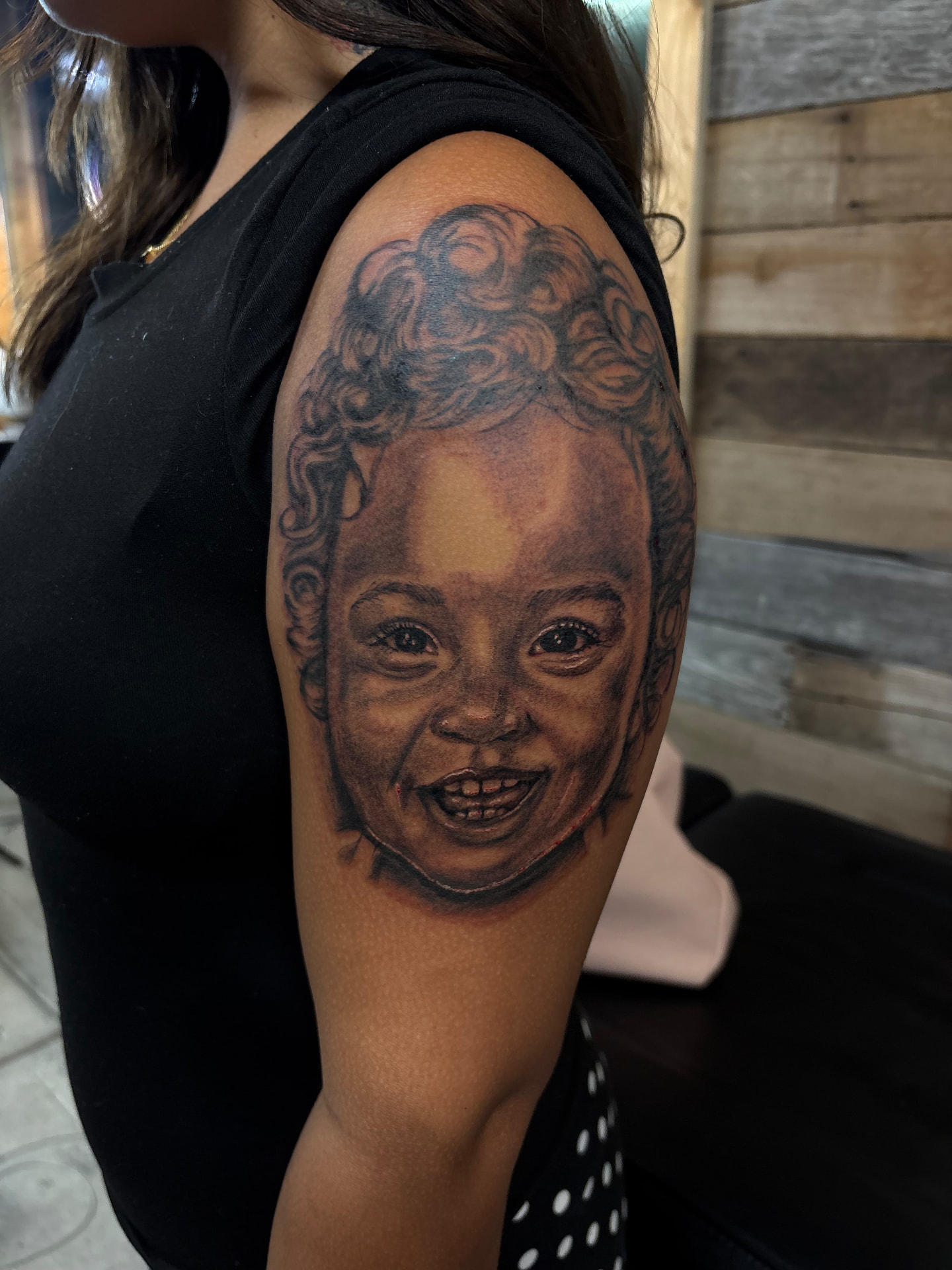 Black and grey realism baby portrait tattoo on shoulder